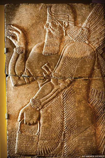 A limestone relief, 883-859 BCE, depicting a winged genie, that decorated a room in the palace of the Syrian ruler Ashurnasirpal II, both from Nimrud, Iraq.