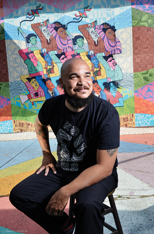 Photo of Chaz Howard at 38th and Lancaster, in front of a mural.