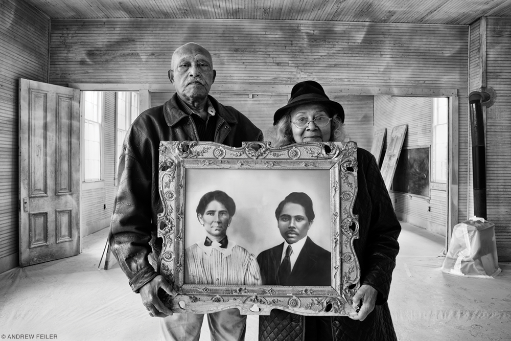 Photo of Elroy and Sophia Williams holding a portrait of Sophia’s grandparents