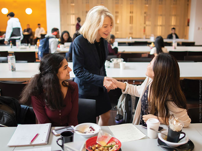 Photo of Penn President Amy Gutmann greeting students in the dining hall at Hill House