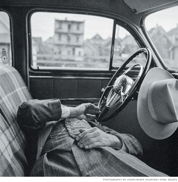 Photo of man in pinstripe suite asleep in car.