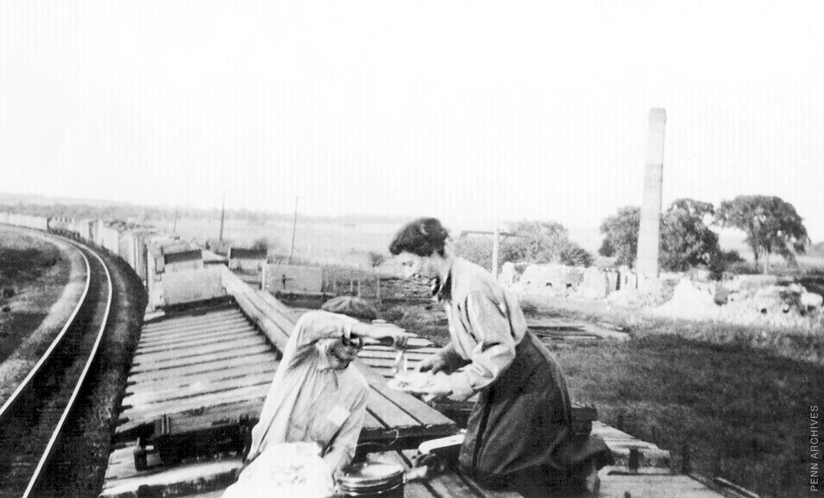 Mary Engle Pennington kneels atop a railcar, collecting food samples for testing.