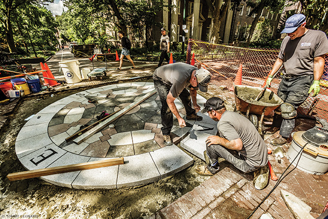 Workers install new stones in compass