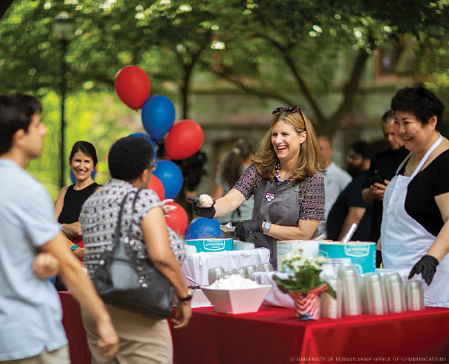 Penn president Liz Magill helps out at an ice cream social on College Green.